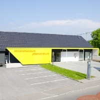Aussenansicht Pfarrheim Lengau, Steildach mit Tondach Dachziegel, Fassadenplatten, Sitzbank in Lärcheholz mit Eternit Fassadenplatten als Lehne
