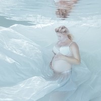 Unterwasserfotoshooting Babybauchaufnahme in großem Stoffrock